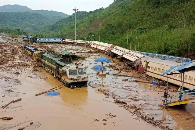 In this photograph taken on May 16, 2022, train carriages are seen toppled over following a landslide caused by a heavy rainfall at New Haflong railway station on the Lumding-Silchar route at Dima Hasao district, some 100 km from Silchar in Assam state. (Photo by AFP Photo/Stringer)