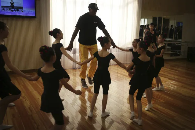 Former NBA basketball star Dennis Rodman dances with school children at the Mangyongdae School Children's Palace on Thursday, June 15, 2017, in Pyongyang, North Korea. (Photo by Kim Kwang Hyon/AP Photo)