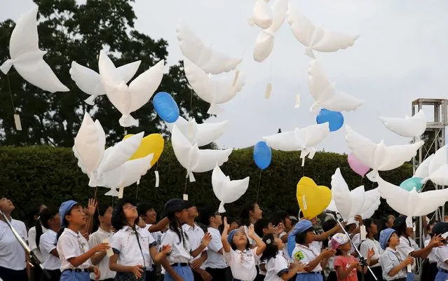 Girls release dove-shaped balloons during an event commemorating the 70th anniversary of the bombing of Nagasaki, at the Nagasaki's Peace Park in Nagasaki, western Japan, August 8, 2015, on the eve of the anniversary. (Photo by Toru Hanai/Reuters)