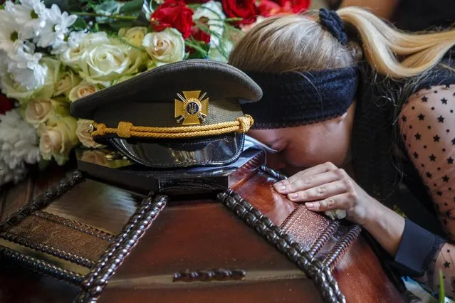 Victoria, the wife of senior (first) lieutenant Vasyl Herych, 31, a service member of the 15th Separate Mountain Assault Battalion, who was killed in a fight during Russia's invasion, reacts during his funeral in Perechyn, Zakarpattia region, Ukraine on June 8, 2022. (Photo by Serhii Hudak/Reuters)