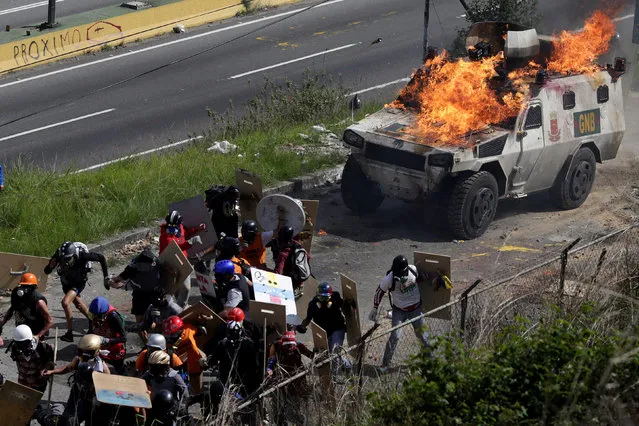 An armored vehicle is seen lit on fire during clashes with demonstrators at a rally against Venezuelan President Nicolas Maduro's government in Caracas, Venezuela, July 18, 2017. (Photo by Marco Bello/Reuters)