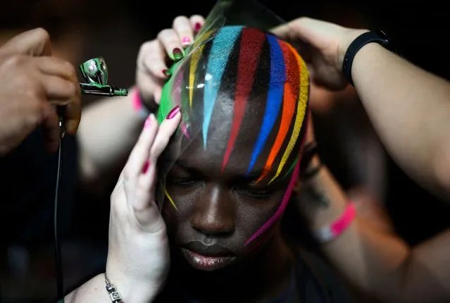 A model has makeup applied backstage ahead of the University of Westminster MA Menswear catwalk show at London Fashion Week in London, Britain on June 12, 2022. (Photo by Henry Nicholls/Reuters)