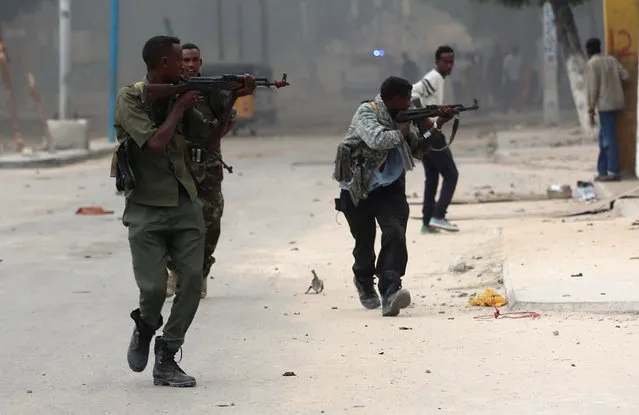 Somali government soldiers run to take their positions during gunfire after a suicide bomb attack outside Nasahablood hotel in Somalia's capital Mogadishu, June 25, 2016. (Photo by Feisal Omar/Reuters)