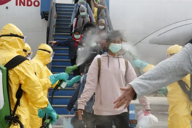 Medical officers spray Indonesian nationals with antiseptic after they arrived from Wuhan, China, before transferring them to be quarantined, at Hang Nadim Airport in Batam, Indonesia, February 2, 2020. (Photo by Antara Foto via Reuters)