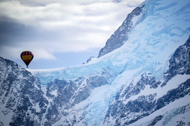 This photograph taken on February 15, 2024, shows a drifing hot air balloon near the L'aiguille du Midi of the Massif du Mont-Blanc mountain range in the French Alps in France. (Photo by Olivier Chassignole/AFP Photo)