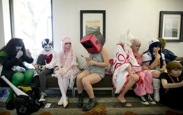 Darby Doran, center, 16, of Cedar Park, considers plugging in her head at Anime Orverload at a Holiday Inn in Austin, Texas, on Sunday, August 16, 2015. The 7th annual Anime Overload is a gathering of about a thousand fans of Japanese animation and pop culture.  The three-day event featured a costume contest, screenings, gaming and vendors. (Photo by Jay Janner/Austin American-Statesman via AP Photo)