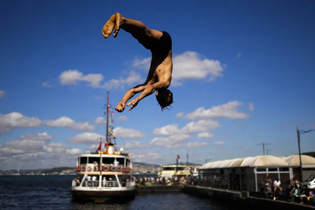 A boy dives from the Galata bridge into the Bosphorus in Istanbul, Turkey, Friday, July 15, 2022. (Photo by Francisco Seco/AP Photo)
