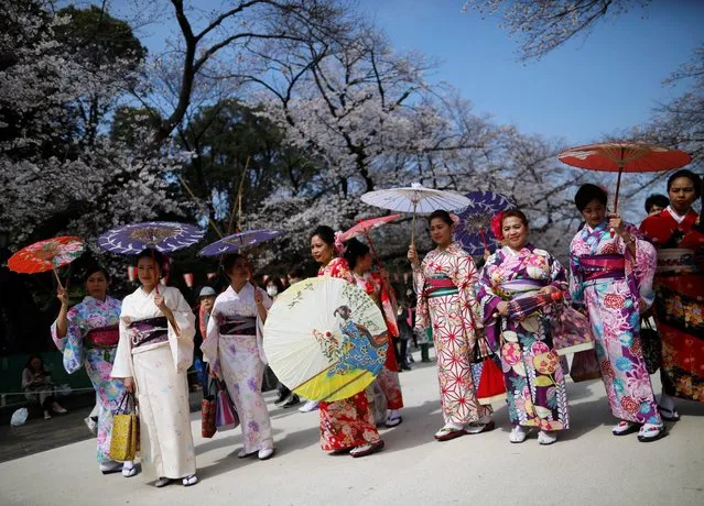 Visitors from abroad wearing kimono clothes look at blooming cherry blossoms at Ueno park in Tokyo, Japan on March 22, 2020. (Photo by Issei Kato/Reuters)