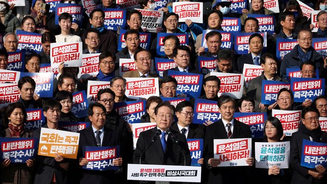 South Korea's main opposition Democratic Party leader Lee Jae-myung looks on as people hold placards that read “Step down President Yoon Suk Yeol” and “Investigate his act of rebellion immediately”, at a rally to condemn South Korean President’s surprise declarations of the martial law last night and to call for his resignation, at the national assembly in Seoul, South Korea, on December 4, 2024. (Photo by Kim Hong-Ji/Reuters)