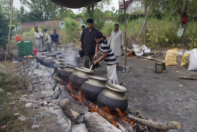 Kashmiri Muslim volunteers prepare food for distribution to the attendants of patients at Kashmir's main hospital Sher-I-Kashmir Institute of Medical Sciences on the eleventh straight day of curfew in Srinagar, Indian controlled Kashmir, Tuesday, July 19, 2016. (Photo by Dar Yasin/AP Photo)