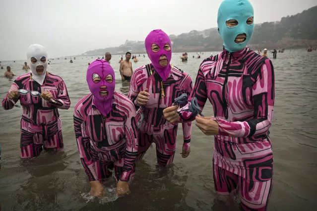 Chinese women wear face-kinis as they stand in the water on August 20, 2014 on the Yellow Sea in Qingdao, China. (Photo by Kevin Frayer/Getty Images)