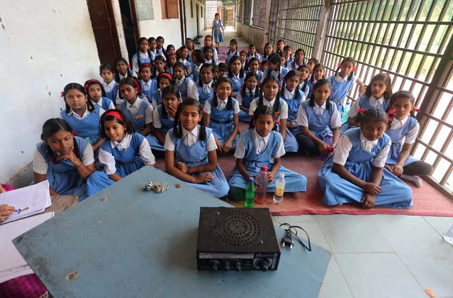 Indian pupils listen to a radio broadcast of a speech marking Teachers' Day at a school in Bhopal, India, 04 September 2015. Teachers' Day commemorates  the birthday of Sarvepalli Radhakhrishnan, the second President of India who as both a teacher and philosopher made a significant contribution towards the Indian education system, and is observed on the 05 September throughout India since 1962. (Photo by Sanjeev Gupta/EPA)