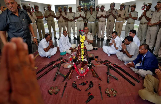 Police officers offer prayers to their weapons as part of a ritual at the police headquarters on the occasion of Vijaya Dashmi, or Dussehra, festival in Ahmedabad, India September 30, 2017. (Photo by Amit Dave/Reuters)