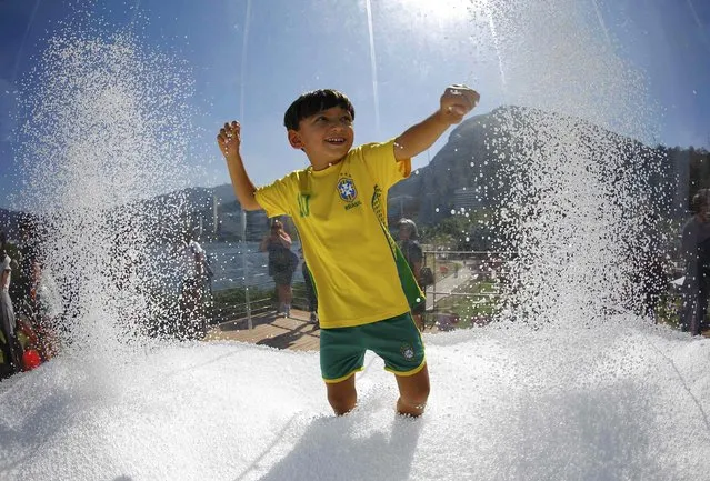 A boy wears a Brazil football shirt as he plays in a display at the Switzerland house in Lagoa, Rio de Janeiro, Brazil on August 1, 2016. (Photo by Ivan Alvarado/Reuters)