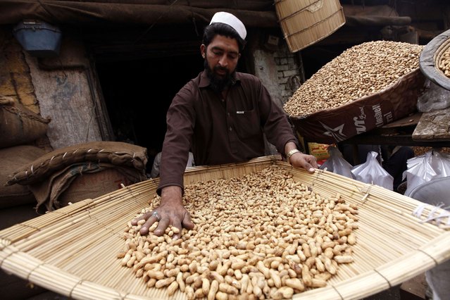 A Pakistani vendor sells peanuts at a peanut market in Peshawar, Pakistan, 23 January 2025. Demand for dried fruits has increased with the onset of winter. Tourists from all over Pakistan come to Peshawar to purchase dried fruits and other items due to price differences between regions of the country. (Photo by Arshad Arbab/EPA/EFE)