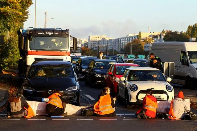 Activists of “Letzte Generation” (Last Generation) block the exit of a highway to protest for a speed limit on highways as well as for affordable public transport, in Berlin, Germany, October 11, 2022. (Photo by Christian Mang/Reuters)