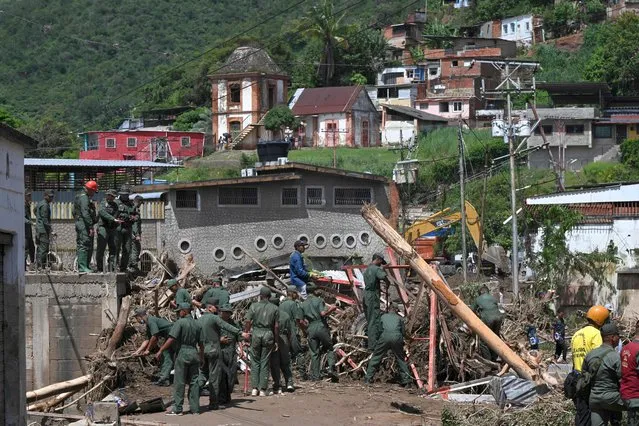 Members of the Venezuelan Army search through the rubble of destroyed houses for victims or survivors after a landslide during heavy rains in Las Tejerias, Aragua state, Venezuela, on October 10, 2022. A landslide in central Venezuela left at least 22 people dead and more than 50 missing after heavy rains caused a river to overflow, Vice President Delcy Rodriguez said Sunday. (Photo by Yuri Cortez/AFP Photo)