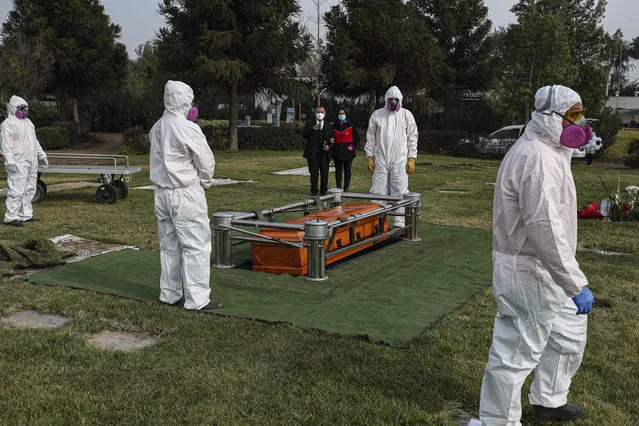 Cemetery workers wearing protective gear against the new coronavirus, walk after carrying the coffin of 72-year-old Monica Lagos to her grave at the Manantial cemetery in Santiago, Chile, Monday, June 15, 2020. According to her grandaughter Ninoska Vasquez, who works as an assistant at a health center, Lagos died from complications related to COVID-19. (Photo by Esteban Felix/AP Photo)