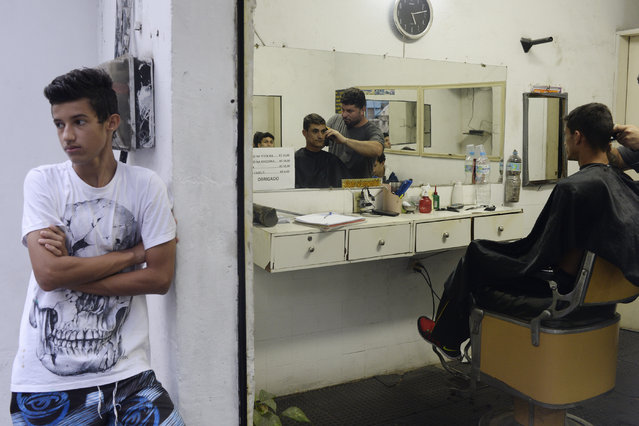 A man gets his haircut by the barber Carlos in the favela Vidigal before the start of the men's gold medal soccer match between Brazil and Germany during Rio 2016 on Saturday, August 20, 2016. (Photo by Aaron Ontiveroz/The Denver Post)