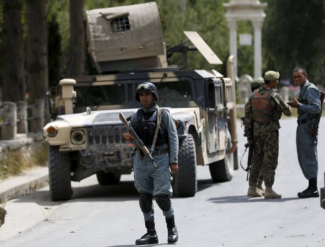 Afghan security forces stand guard near the main gate of Paghman district compound after a suicide bomb attack, north of Kabul, Afghanistan September 16, 2015. (Photo by Omar Sobhani/Reuters)
