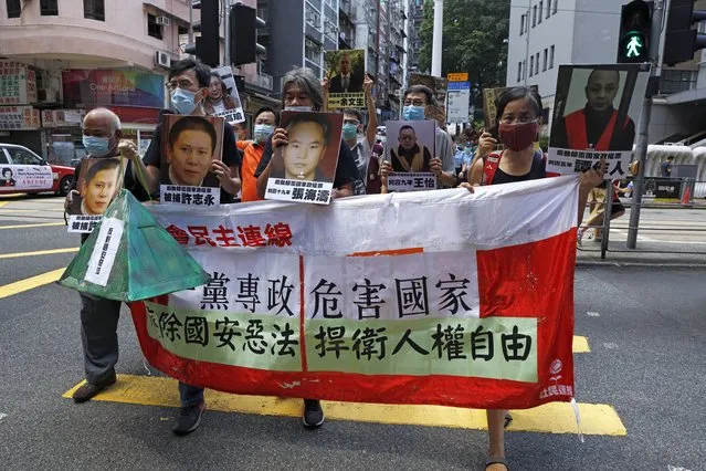 Pro-democracy demonstrators hold up a banner and portraits of jailed Chinese civil rights activists, lawyers and legal activists as they march to the Chinese liaison office in Hong Kong, Thursday, June 25, 2020. The banner read “One-party dictatorship harms the country, abolish the national security law and defend human rights and freedom in Hong Kong”. (Photo by Kin Cheung/AP Photo)