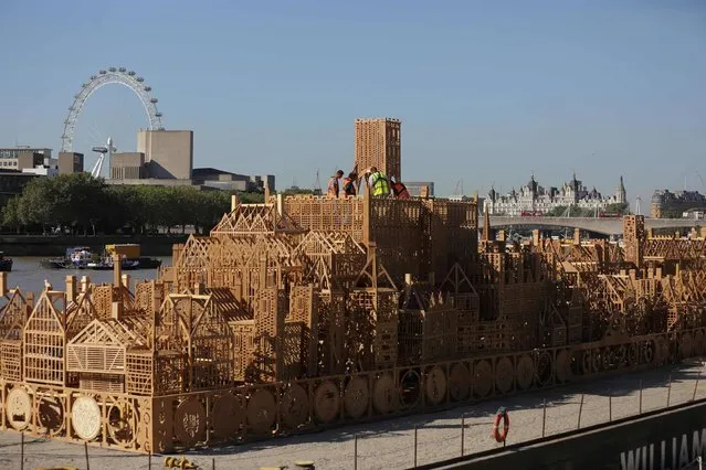 The final touches are made to a 120 metre-long wooden sculpture of London's skyline from the seventeenth century as it is moored up on the river Thames in London on August 30, 2016. The sculpture titled London 1666 and designed by David Best will be ceremonially lit and burnt in the middle of the Thames on September 4 as part of celebrations to commemorate the 350th anniversary of the Great Fire of London. (Photo by Daniel Leal-Olivas/AFP Photo)