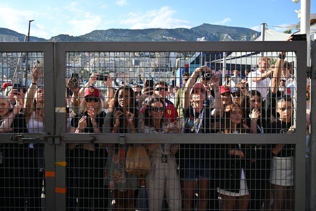 Fans stretch to look into the pit lane at the end of the qualifying session for the Formula One Monaco Grand Prix at the Circuit de Monaco, on May 24, 2025. (Photo by Andrej Isaković/AFP Photo)
