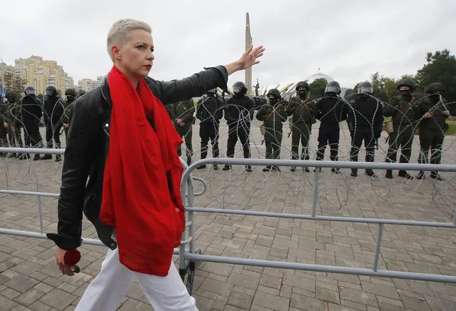 Maria Kolesnikova, one of opposition leaders, walks past riot policemen blocking the streets during protests in Minsk, Belarus, Sunday, August 23, 2020. (Photo by Dmitri Lovetsky/AP Photo)