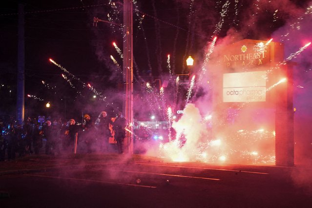 Police officers stand next to fireworks thrown at them as they try to disperse the demonstrators gathered for a protest against federal immigration sweeps, in Atlanta, Georgia, on June 10, 2025. (Photo by Megan Varner/Reuters)