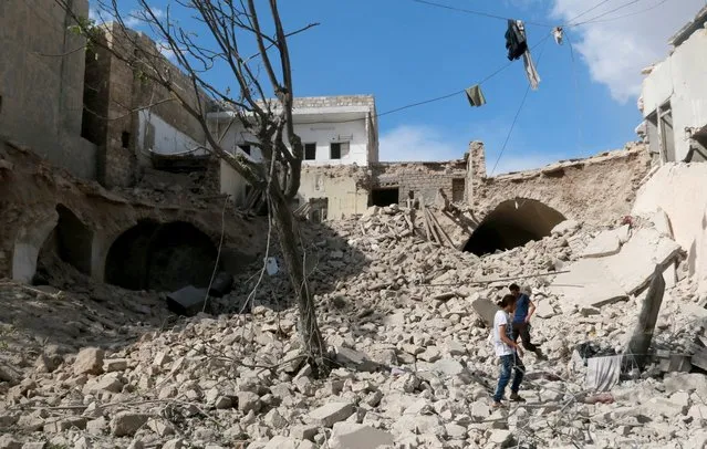 Syrians walk over the debris of a collapsed building after Syrian and Russian army carried out an airstrike on opposition controlled residential area at Maadi town of Aleppo, Syria on September 23, 2016. (Photo by Jawad al Rifai/Anadolu Agency/Getty Images)