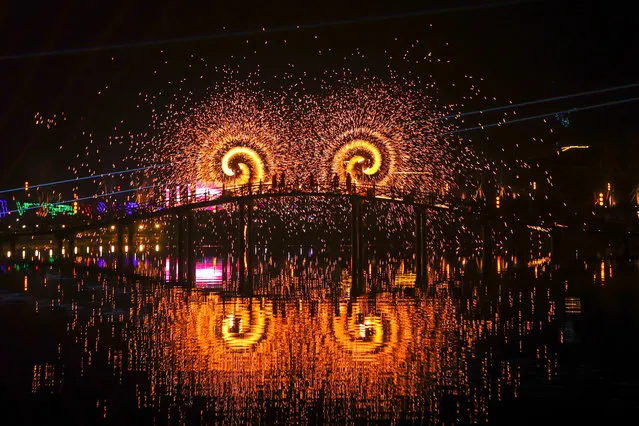 Folk artists perform “iron flowers”, a folk art performance of throwing molten iron to create fireworks, in Daying County of Suining City, southwest China's Sichuan Province on January 26, 2023. (Photo by Xinhua News Agency/Rex Features/Shutterstock)