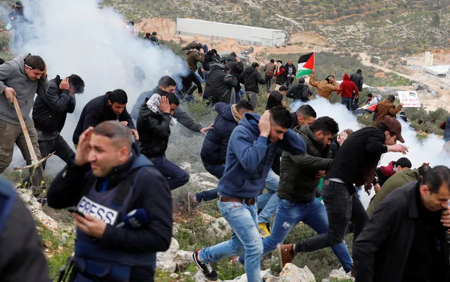 Palestinian demonstrators run for cover during clashes with Israeli troops at a protest against Jewish settlements in the village of Beita, near Nablus in the occupied West Bank February 15, 2018. (Photo by Mohamad Torokman/Reuters)