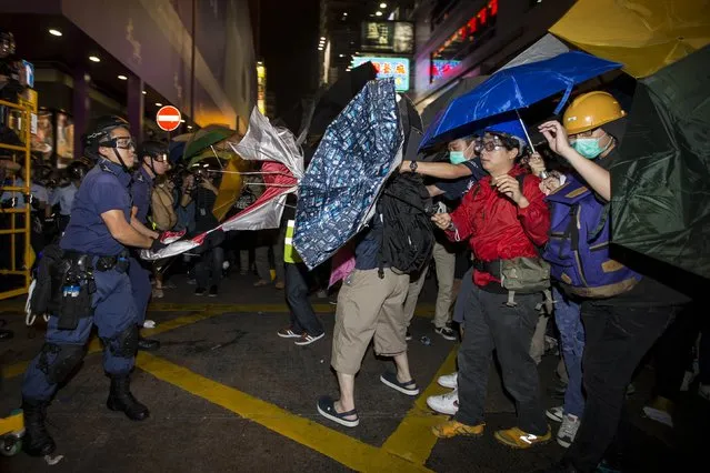 A riot police officer takes an umbrella from a pro-democracy protester during a confrontation at Mongkok shopping district in Hong Kong November 25,2014. Scuffles erupted after Hong Kong authorities cleared part of a pro-democracy protest camp in the bustling district of Mong Kok on Tuesday following a court order to reopen a road, with several demonstrators taken away in police vans. (Photo by Tyrone Siu/Reuters)
