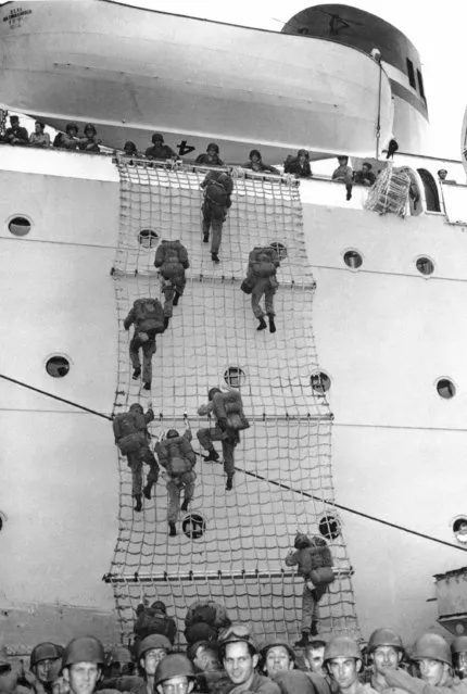 American troops leave a troop transport by nets into an LSU enroute to a landing in Korea on July 25, 1950. (Photo by AP Photo/U.S. Army)