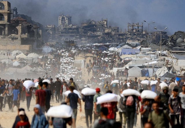 Palestinians gather as they carry aid supplies that entered Gaza through Israel, amid a hunger crisis, in Beit Lahia in the northern Gaza Strip on July 20, 2025. (Photo by Dawoud Abu Alkas/Reuters)