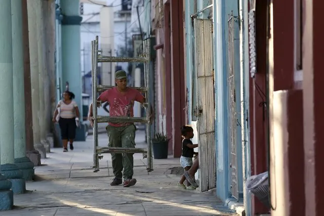 A man carries scaffolding in Havana October 26, 2015. (Photo by Reuters/Stringer)