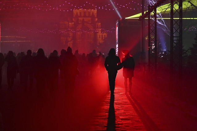A couple walks watching a light installation “The Bridge of Memory” marking the 80th anniversary of the Soviet victory in the battle of Stalingrad in the southern Russian city of Volgograd, once known as Stalingrad, Russia, Wednesday, February 1, 2023. The battle of Stalingrad turned the tide of World War II and is regarded as the bloodiest battle in history, with the death toll for soldiers and civilians estimated at about 2 million. (Photo by AP Photo/Stringer)