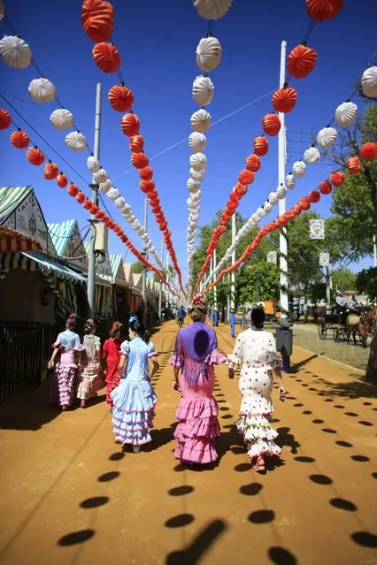 Women wearing typical Sevillana outfits walk during the traditional Feria de Abril (April fair) in the Andalusian capital of Seville, southern Spain April 17, 2013. (Photo by Marcelo del Pozo/Reuters)