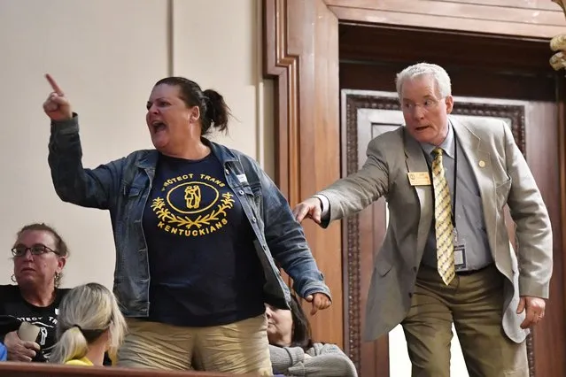 A visitor in the Kentucky Senate Gallery is escorted out by a doorkeeper as she shouts in anger at the passage of Senate Bill 150 at the Kentucky Senate in Frankfort, Ky., Thursday, March 16, 2023. (Photo by Timothy D. Easley/AP Photo)