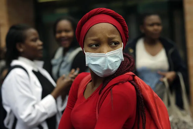 A medical students stares at a line of security officers at the University of the Witwatersrand's medical school in Johannesburg, South Africa, Friday, October 21 2016. Protests calling for free education have sometimes turned violent and have affected  many South African universities since last month. (Photo by Jerome Delay/AP Photo)