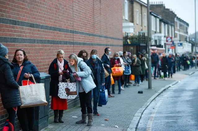People queue outside the Waitrose and Partners supermarket, amid the coronavirus disease (COVID-19) outbreak, Balham, London, Britain on December 22, 2020. (Photo by Hannah McKay/Reuters)