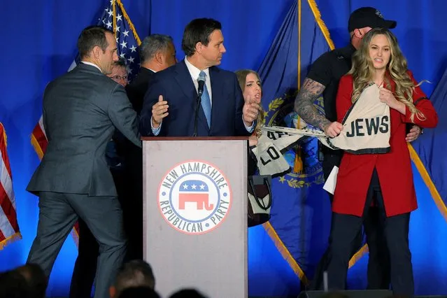 Demonstrators interrupt Florida Governor Ron DeSantis as he speaks at the 2023 NHGOP Amos Tuck Dinner in Manchester, New Hampshire, U.S., April 14, 2023. (Photo by Brian Snyder/Reuters)
