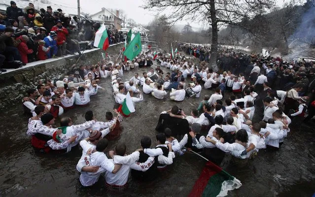 Bulgarian men dance in the icy waters of the Tundzha river during a celebration to commemorate Epiphany Day in the town of Kalofer January 6, 2015. (Photo by Stoyan Nenov/Reuters)