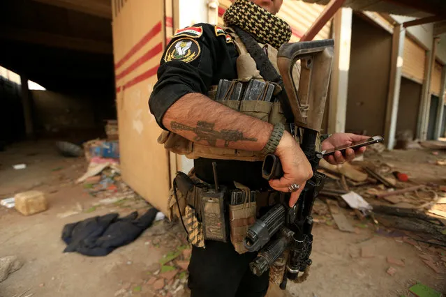 An Iraqi special forces soldier stands beside a store used by Islamic State militants in Bartilla, east of Mosul, Iraq October 27, 2016. (Photo by Zohra Bensemra/Reuters)