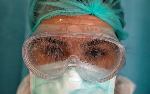 Nurse Dilara Fahrioglu's goggles are covered with vapor after taking care of a patient suffering from COVID-19 at an intensive care unit of the Medicana International Hospital in Istanbul, Turkey, April 14, 2020. (Photo by Umit Bektas/Reuters)