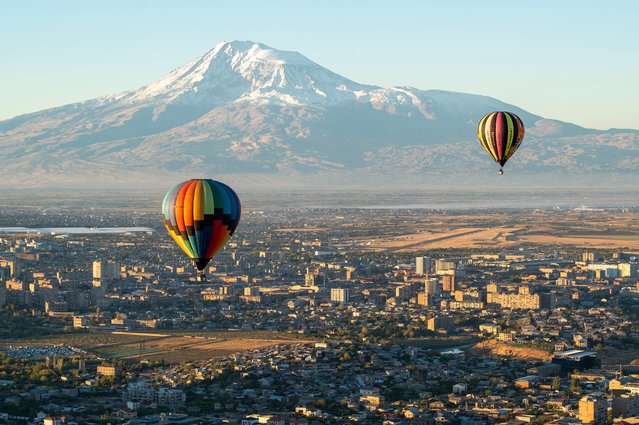 Ballooning enthusiasts fly their hot-air balloons over the Armenian capital of Yerevan, with Mount Ararat seen in distance, on October 14, 2025. (Photo by Karen Minasyan/AFP Photo)