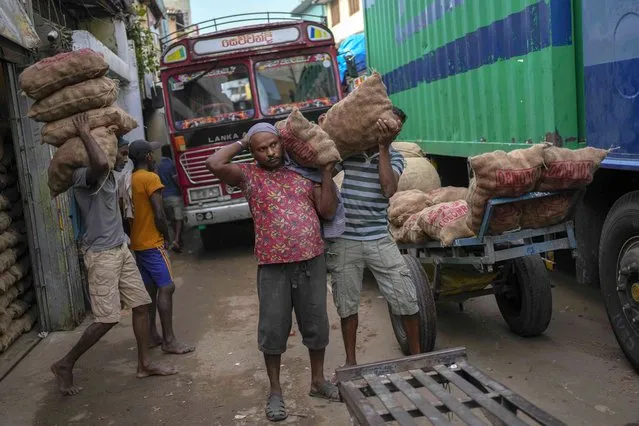 Laborers load sacks of imported potatoes to hand carts at a market place in Colombo, Sri Lanka, Tuesday, March 21, 2023.(Photo by Eranga Jayawardena/AP Photo)