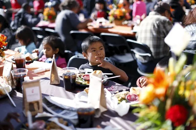 A boy eats an early Thanksgiving meal served to the homeless at the Los Angeles Mission in Los Angeles, California, November 25, 2015. (Photo by Mario Anzuoni/Reuters)