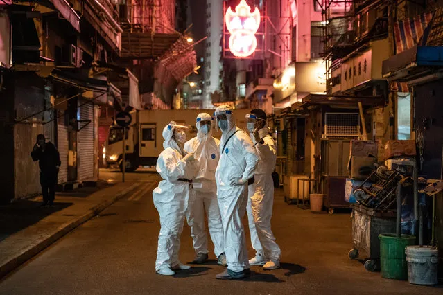 Government workers wearing personal protective equipment on a street in the locked-down part of the Jordon district on January 24, 2021 in Hong Kong, China. Hong Kong government locked-down tens of thousand of residents to contain a worsening outbreak of the coronavirus. Residents tested negative for Covid-19 can now leave and re-enter the area and the restriction is expected to lift by midnight. (Photo by Anthony Kwan/Getty Images)
