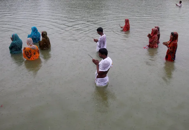 Hindu devotees worship the Sun god in a pond as it rains during Chhat Puja in Agartala, India, November 6, 2016. (Photo by Jayanta Dey/Reuters)